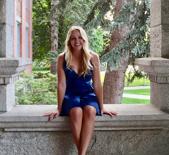 창가 옆에 팔을 교차한 채 서 있는 여성